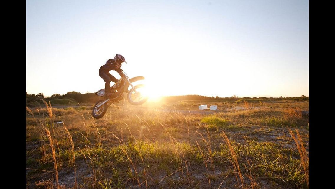 Side view of man riding motorbike on countryside landscape