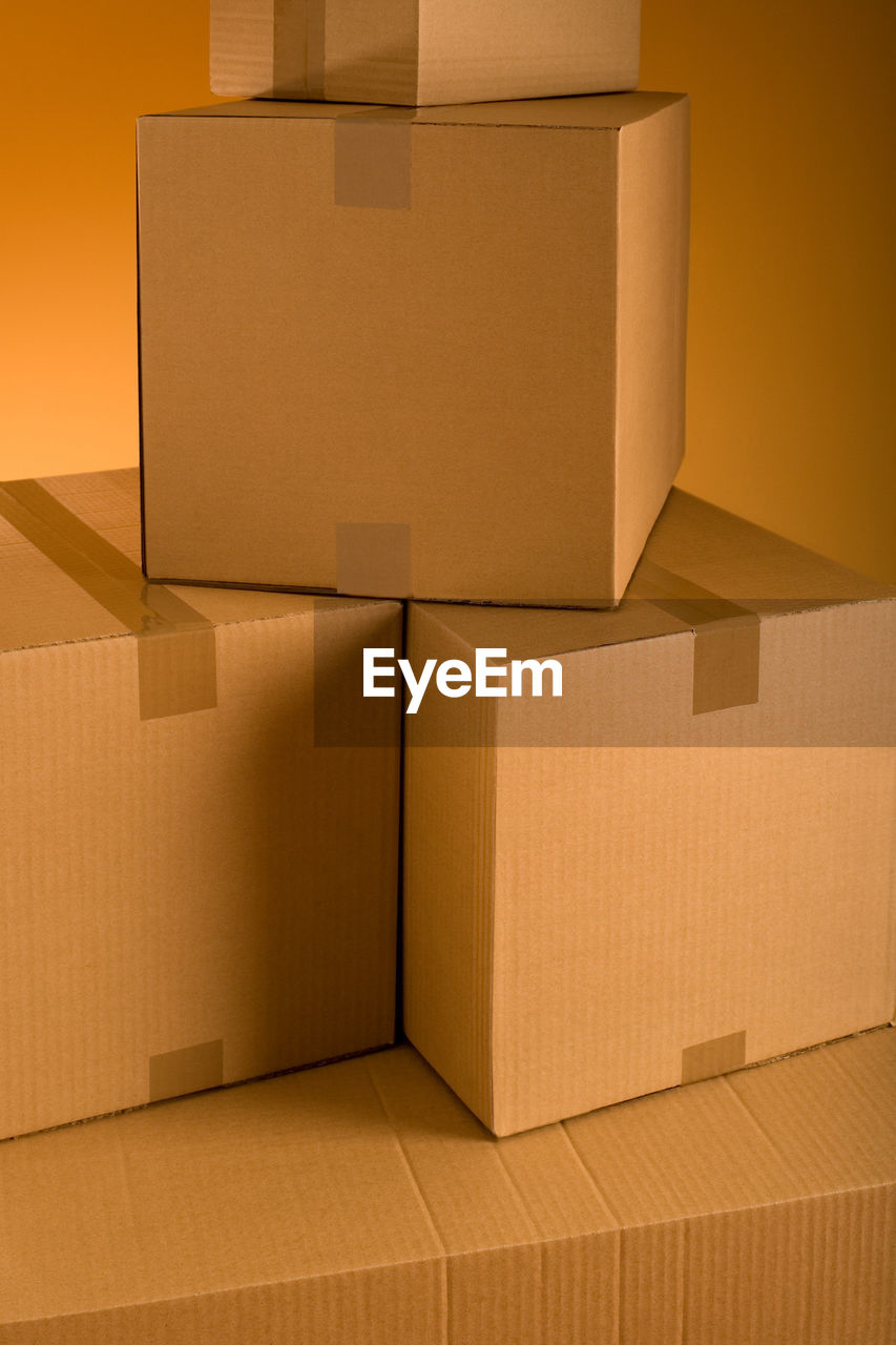 Stack of cardboard boxes against colored background