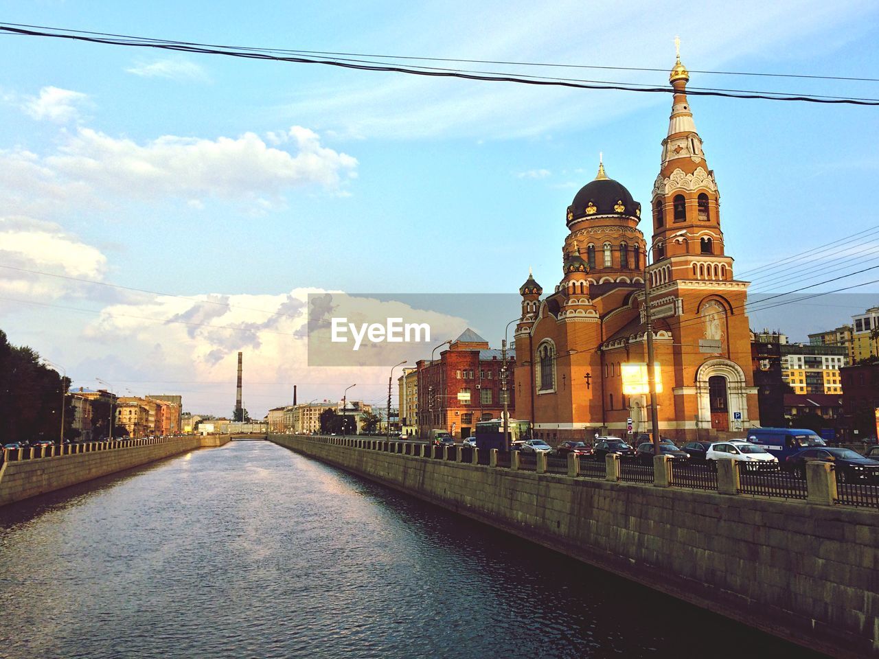 Canal amidst buildings against sky in city