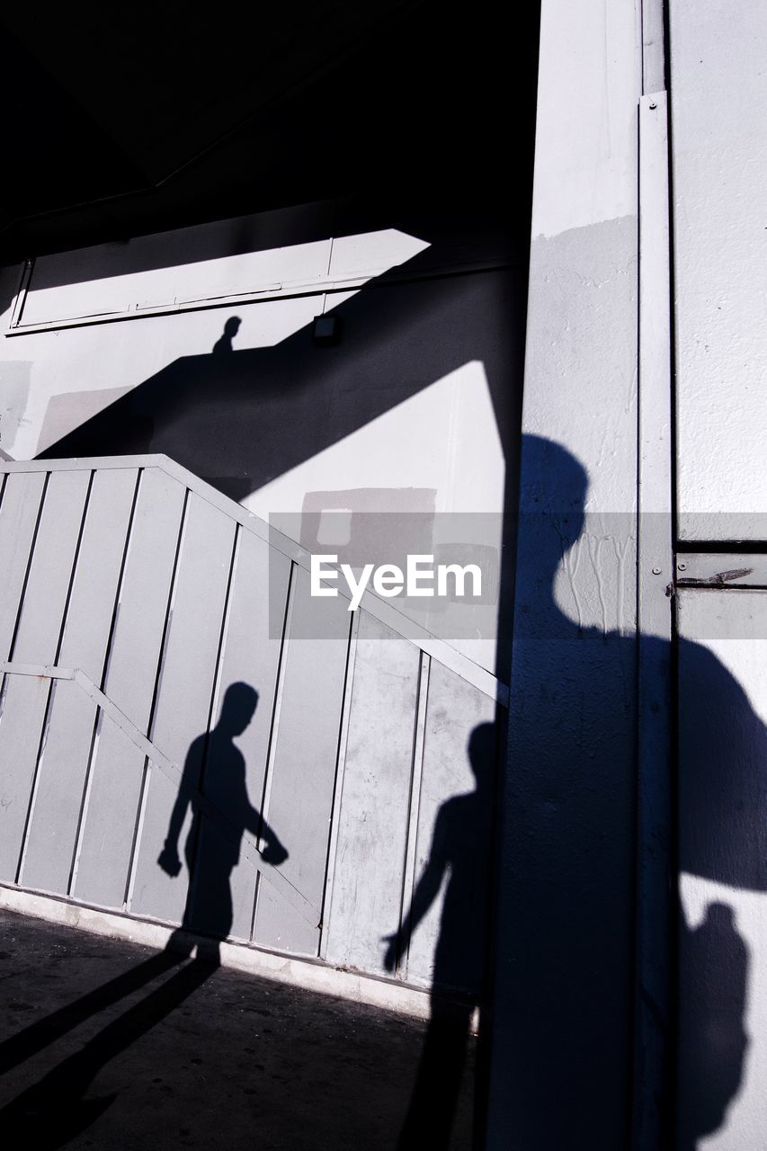 SILHOUETTE MAN WALKING ON BUILDING WALL