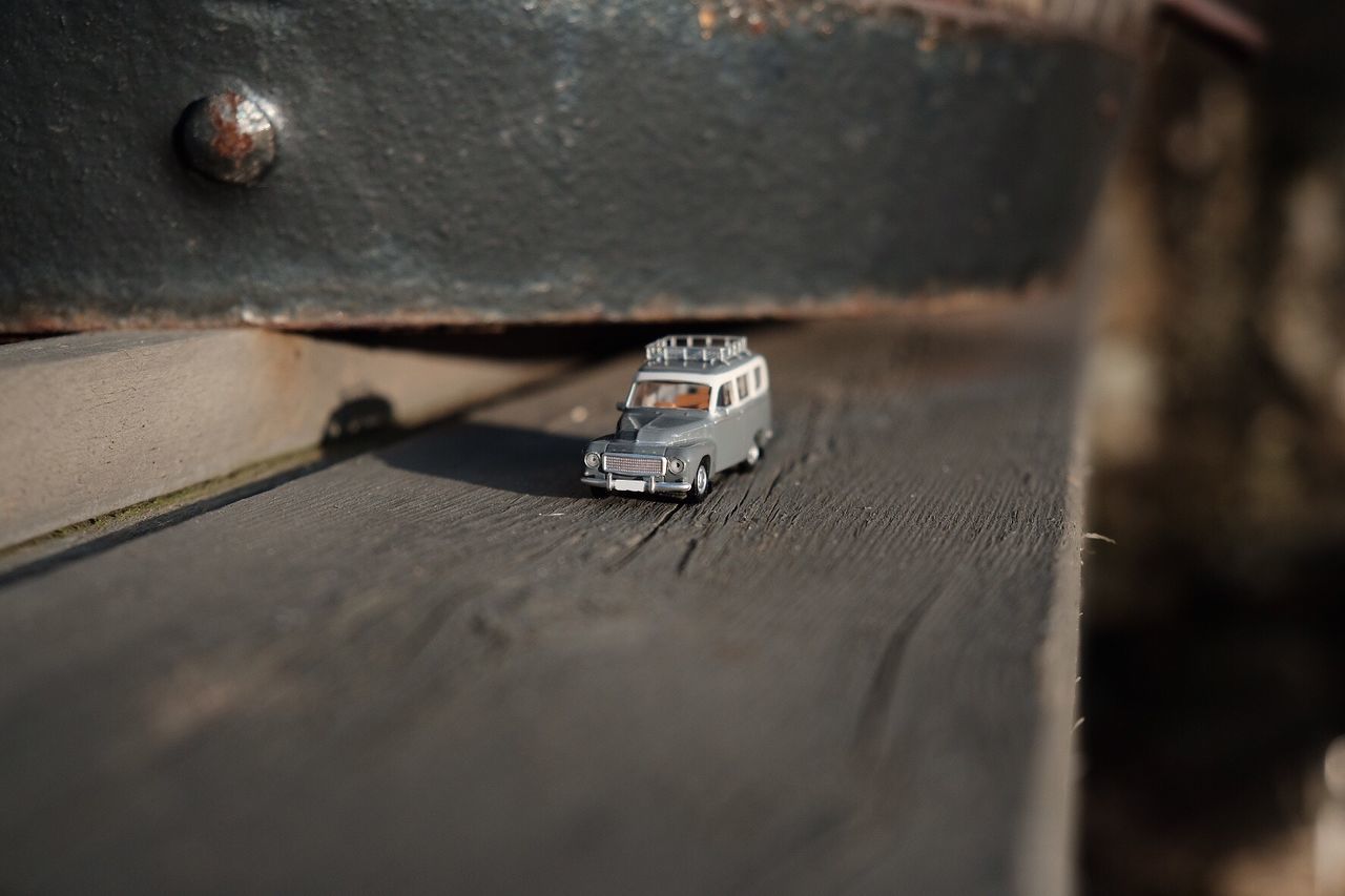 Tilt shift image of toy car on wood