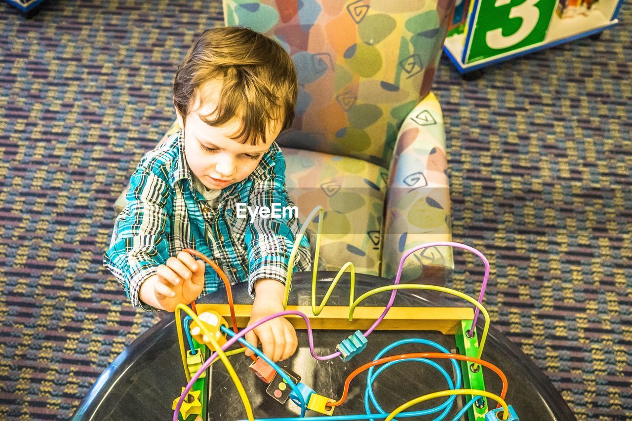 High angle view of boy playing with toy at home