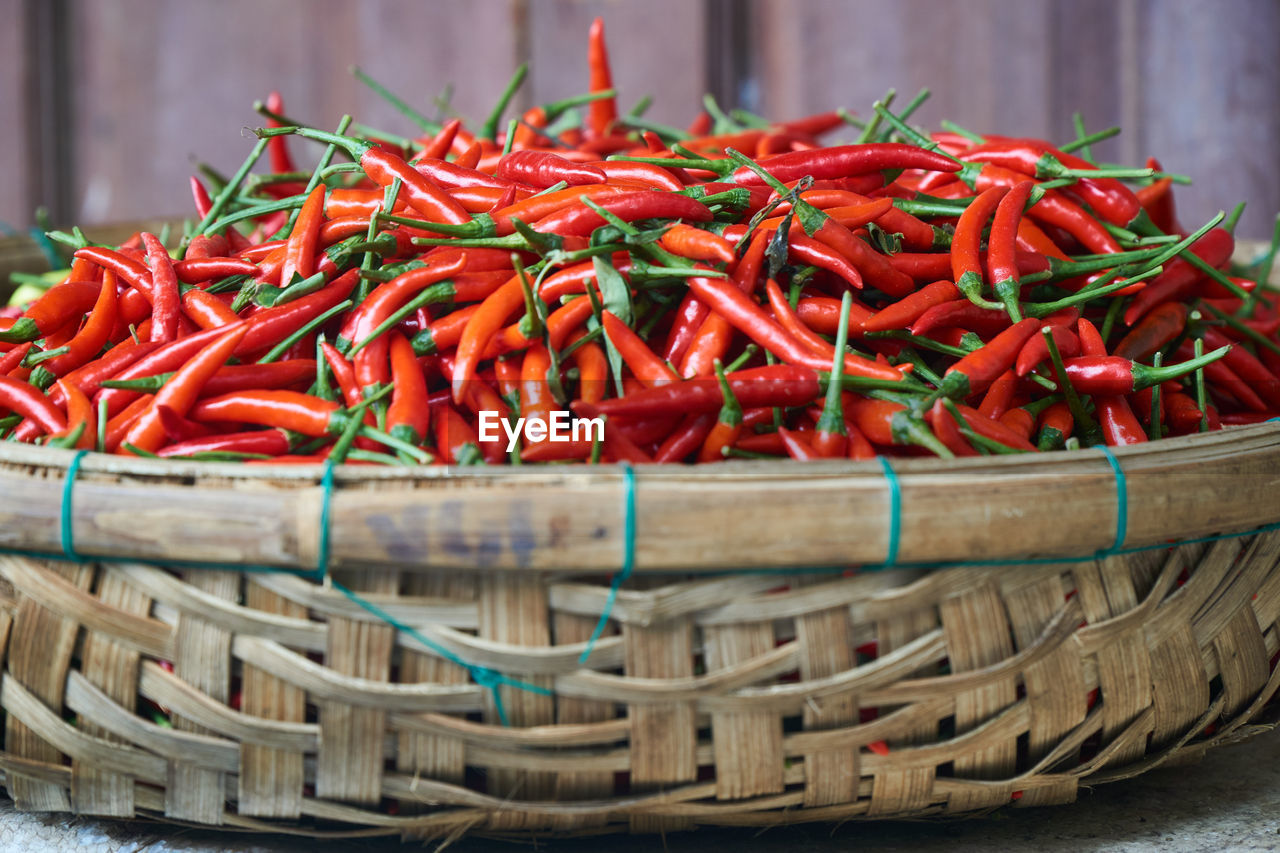 CLOSE-UP OF RED CHILI PEPPERS IN BASKET FOR SALE