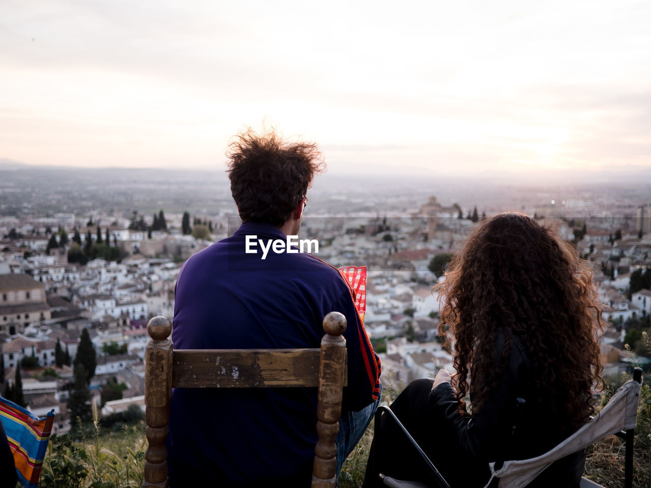 REAR VIEW OF A WOMAN OVERLOOKING CITYSCAPE