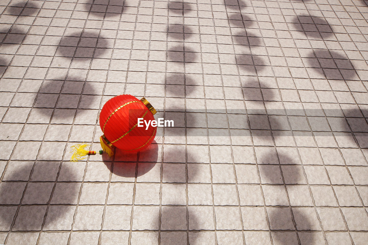HIGH ANGLE VIEW OF RED BALL ON FLOOR