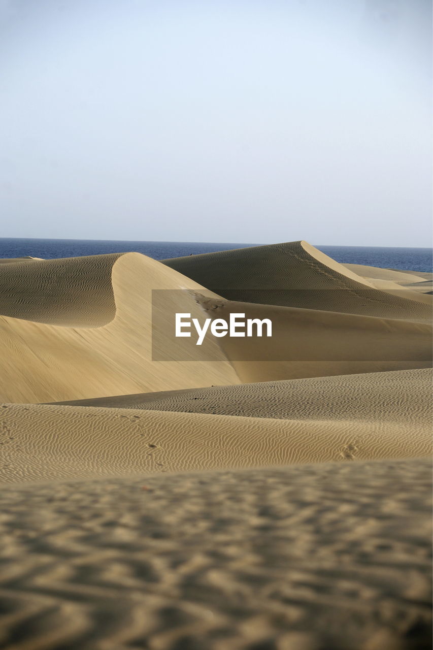 Scenic view of desert against sea