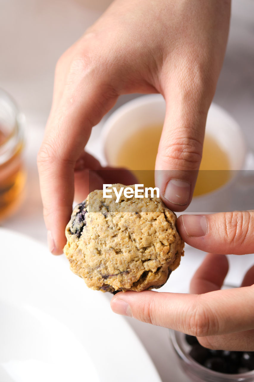 CLOSE-UP OF HANDS HOLDING COOKIES