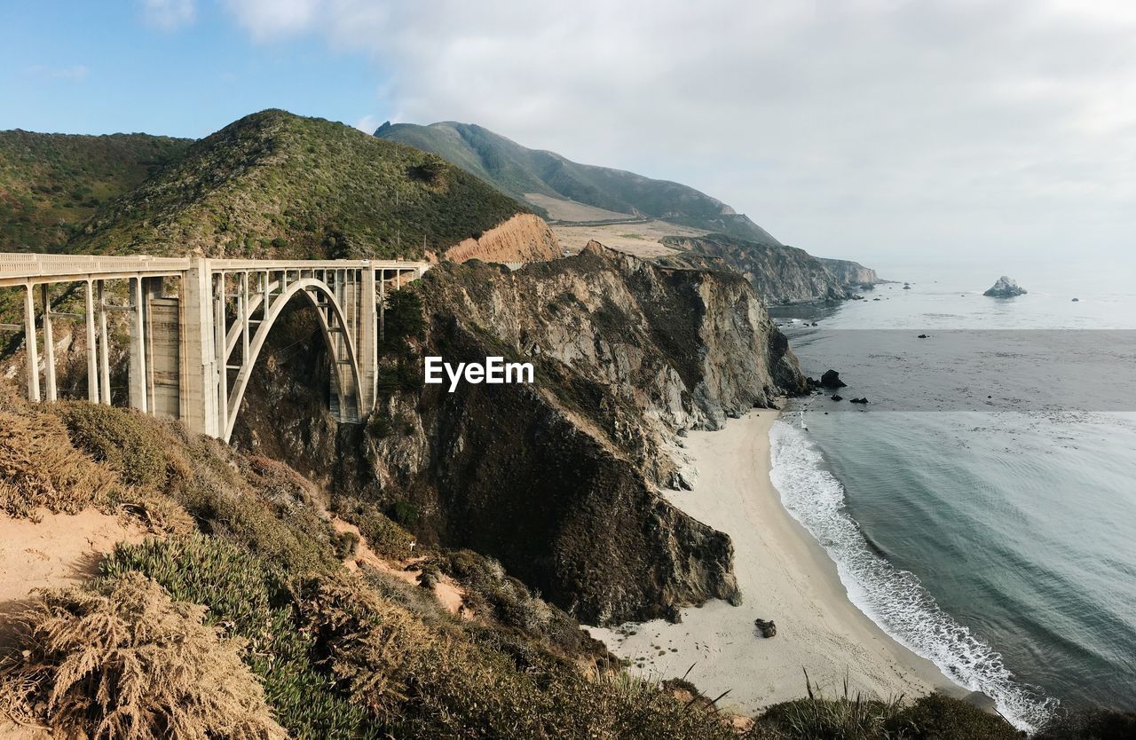Arch bridge over sea against sky