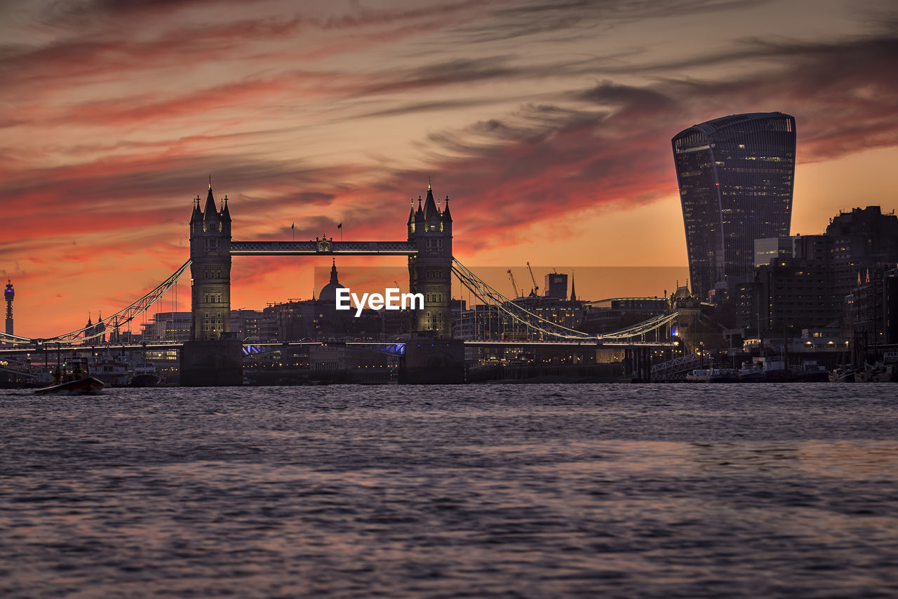 VIEW OF BRIDGE OVER RIVER AT SUNSET