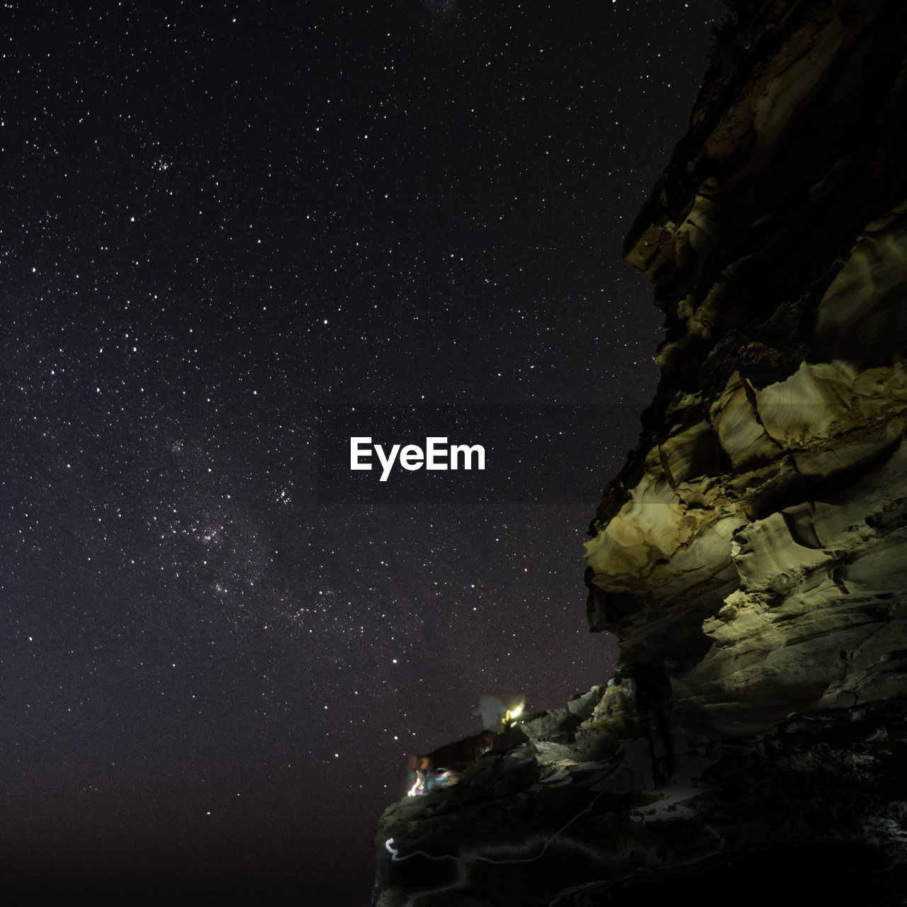 Scenic view of cliff against star field at night