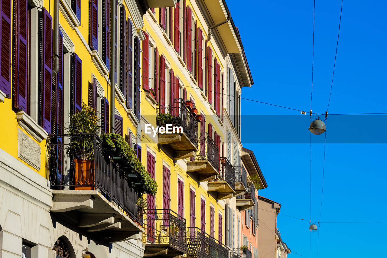 LOW ANGLE VIEW OF RESIDENTIAL BUILDINGS AGAINST BLUE SKY