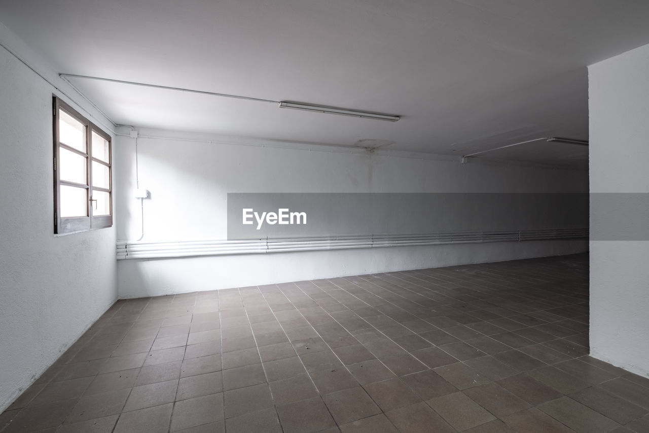 architecture, indoors, flooring, floor, building, wall - building feature, no people, built structure, empty, hall, home interior, house, corridor, arcade, interior design, window, entrance, sparse, door, light - natural phenomenon, wall, absence, ceiling, room, domestic room, tiled floor, lighting equipment