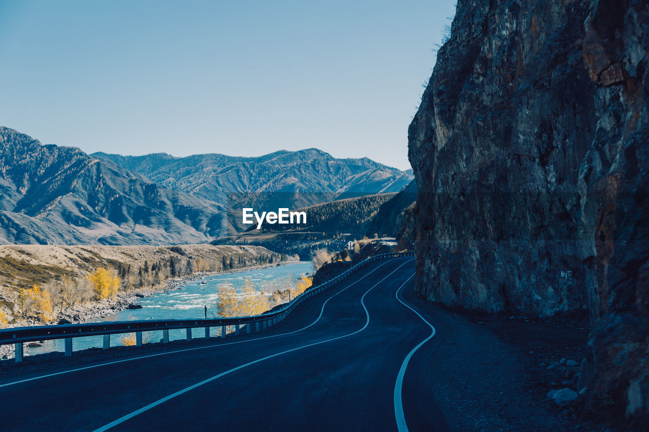 Road amidst mountains against clear sky