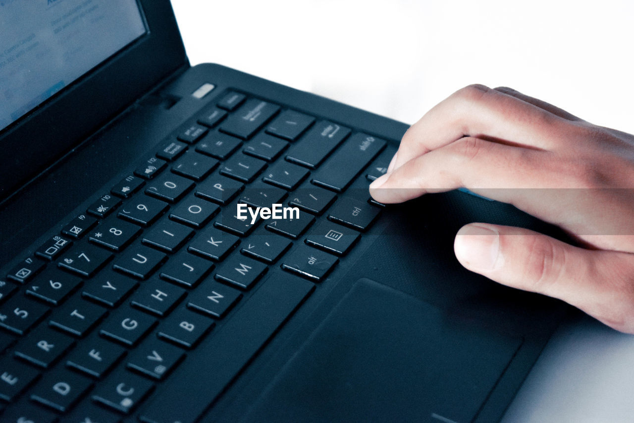 CLOSE-UP OF MAN USING LAPTOP