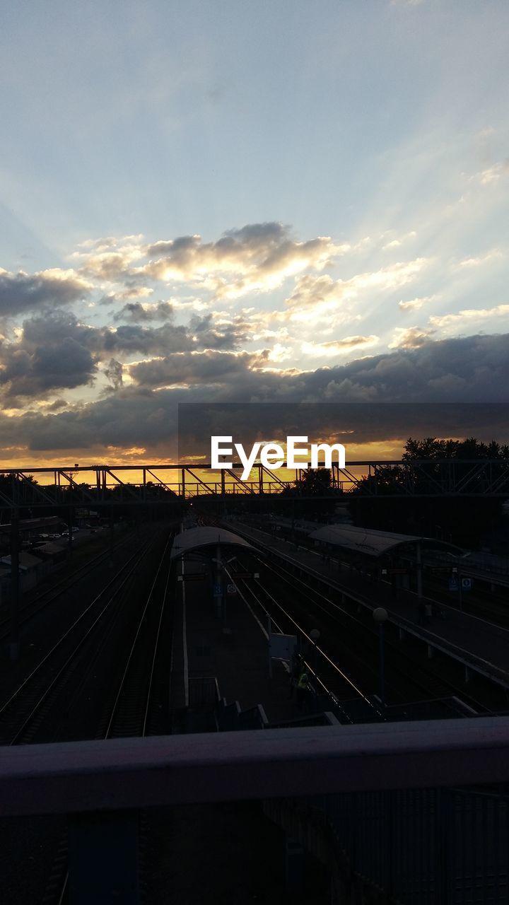 RAILROAD TRACK AGAINST SKY DURING SUNSET