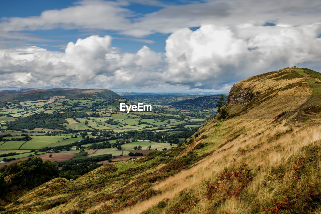 Scenic view of terraced field by mountain against cloudy sky