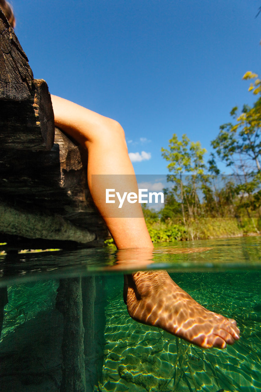 Underwater view of woman legs in plitvice lakes, croatia