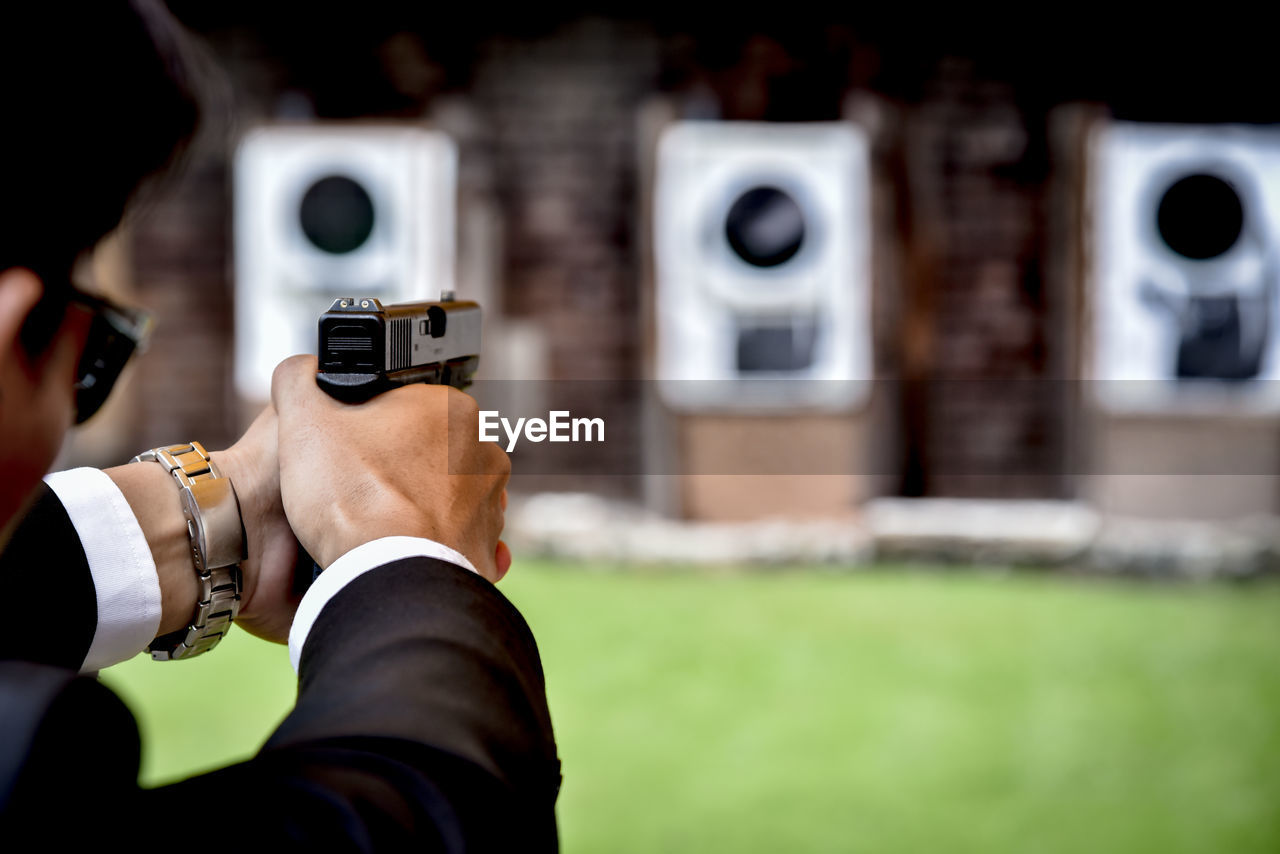 Close-up of man aiming gun during target shooting