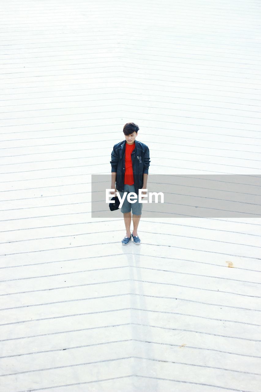 High angle view of young man standing on walkway