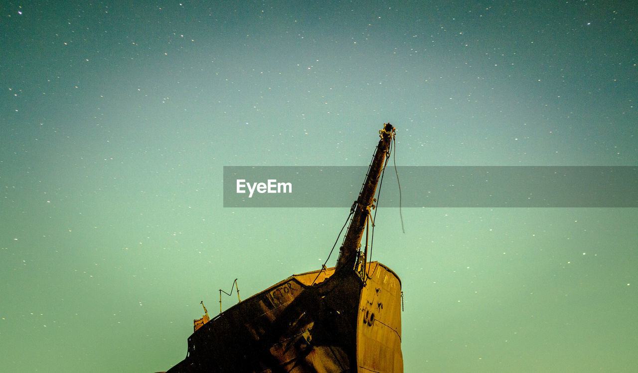 Low angle view of damaged ship against sky at night