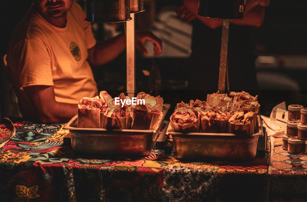 food and drink, food, one person, business, freshness, occupation, business finance and industry, market, market stall, adult, retail, night, small business, men, fast food, street food, asian food, for sale, indoors, working, concession stand