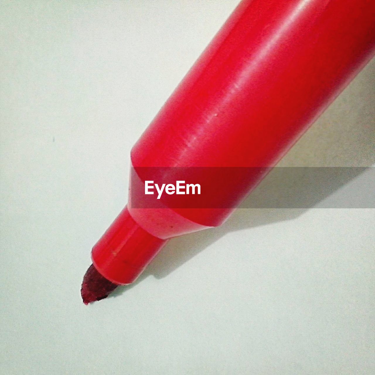 Close-up of red felt tip pen on white paper