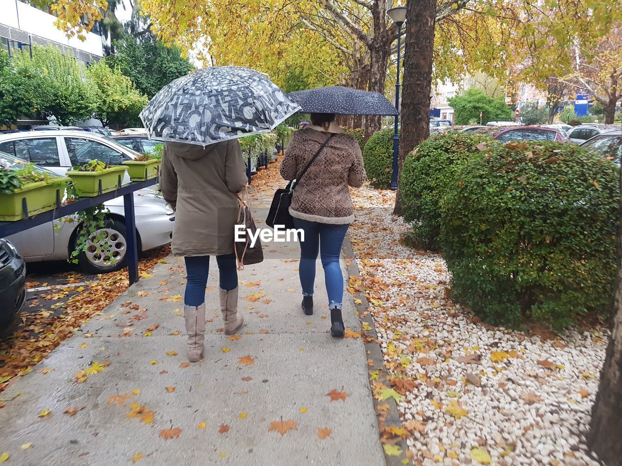 REAR VIEW OF PEOPLE WALKING ON STREET