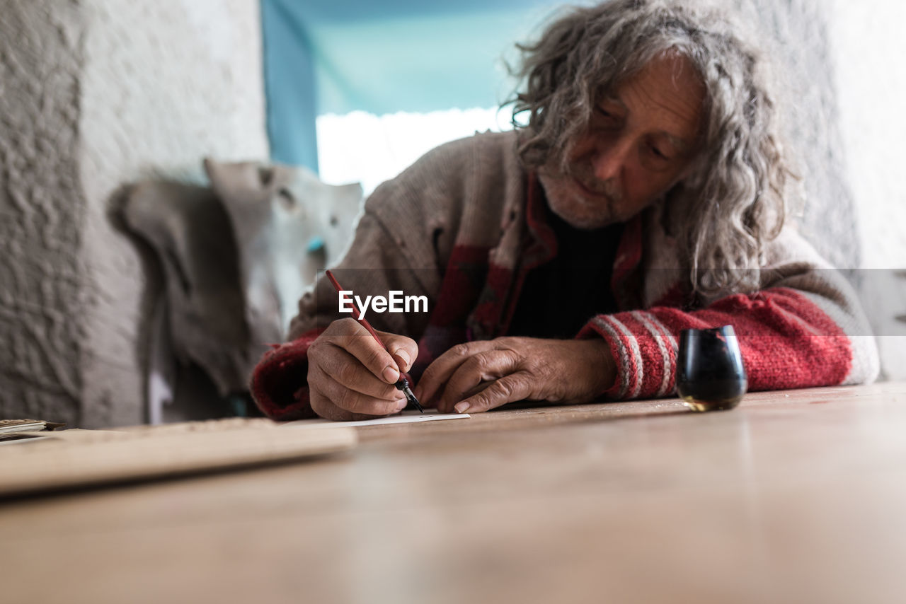 Senior man writing on paper