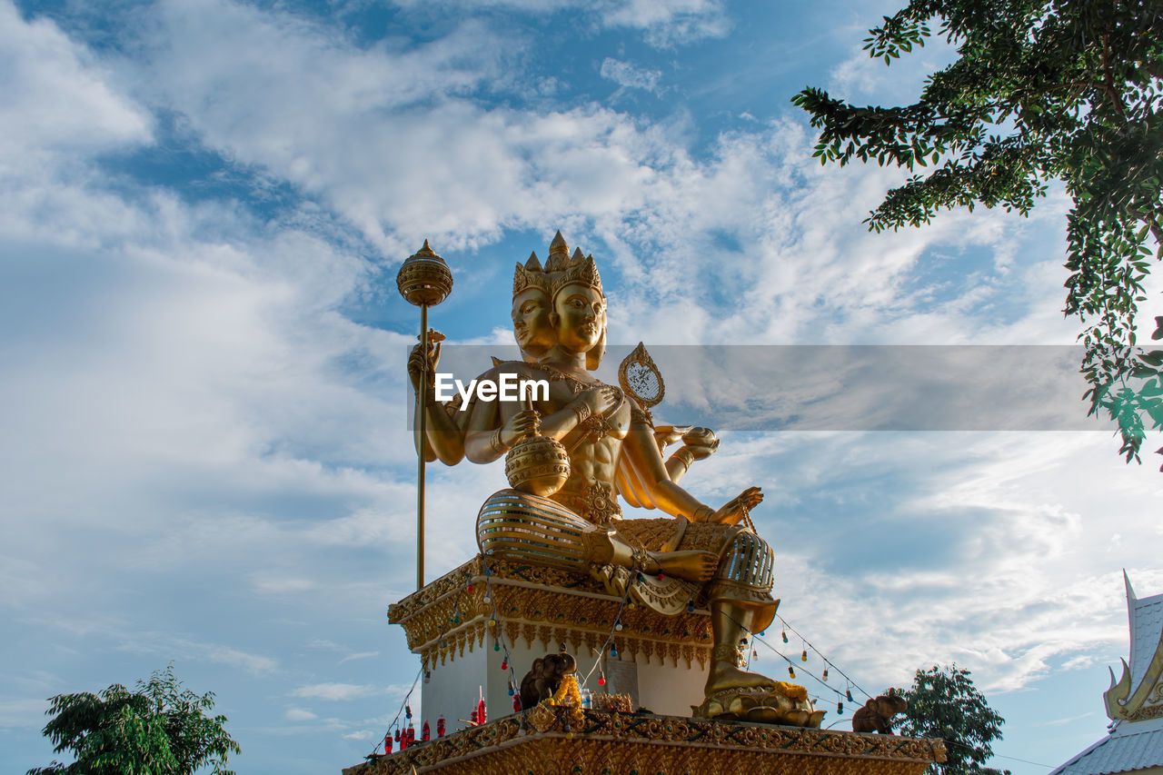 Low angle view of buddha statue against sky