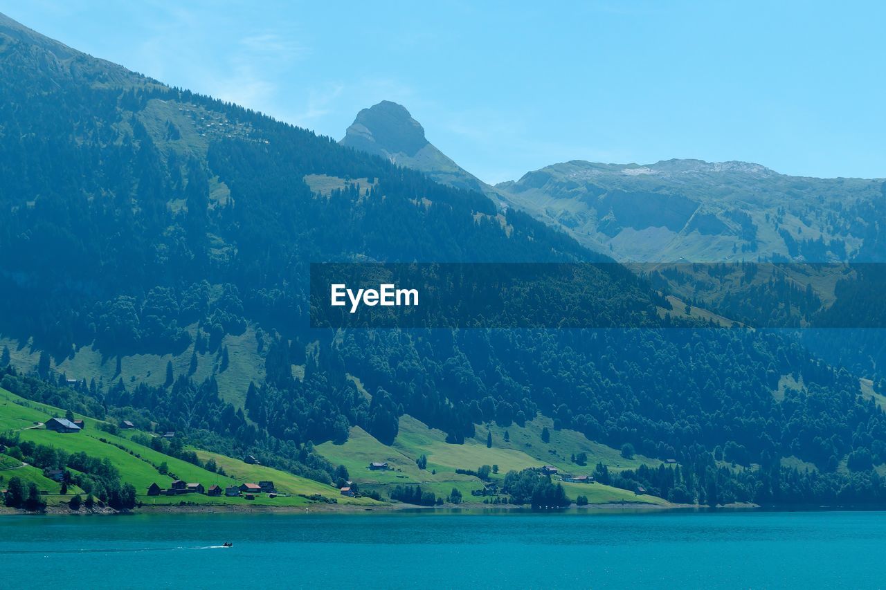 Scenic view of sea and mountains against sky