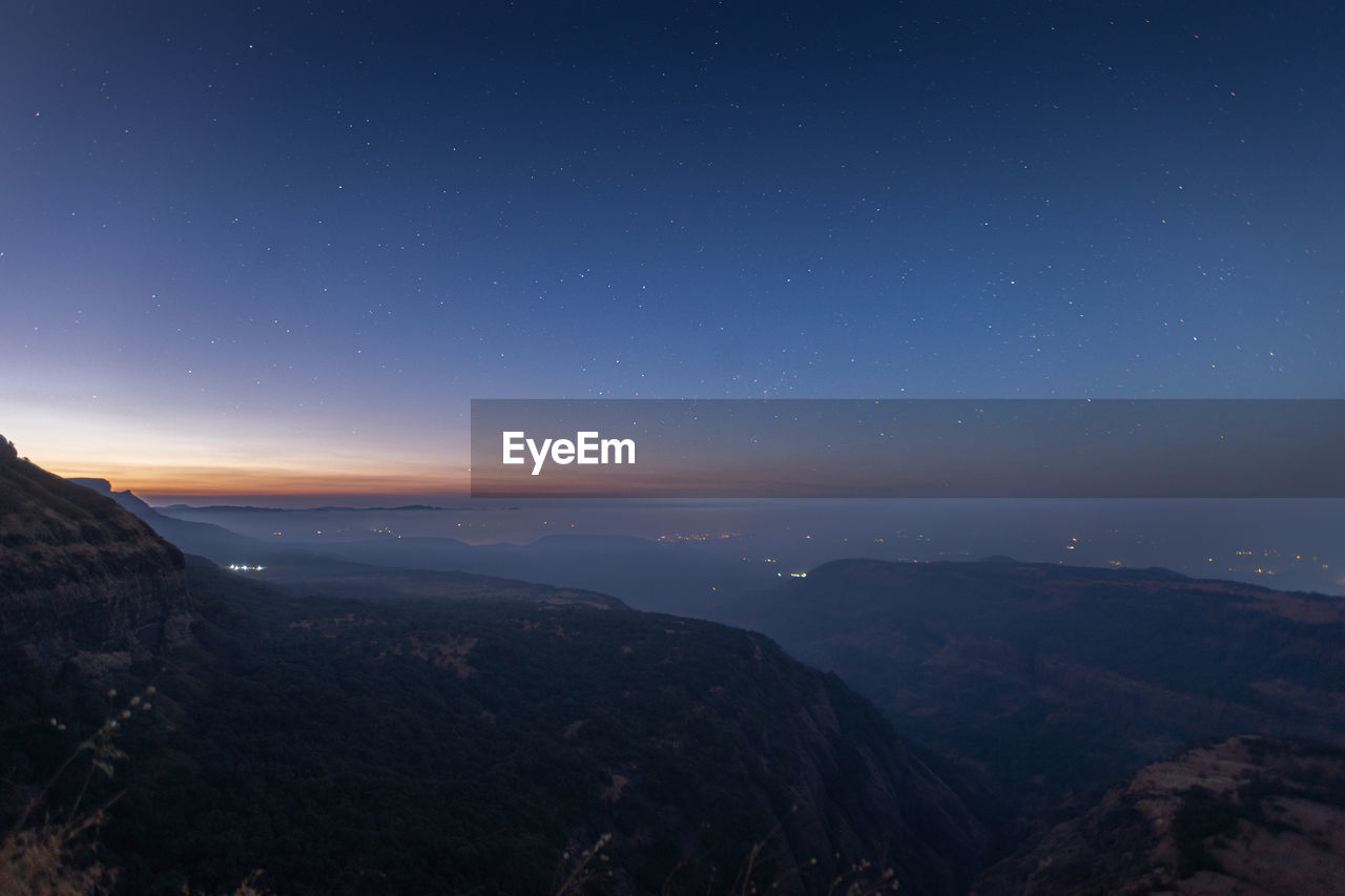 Scenic view of mountains against sky at night