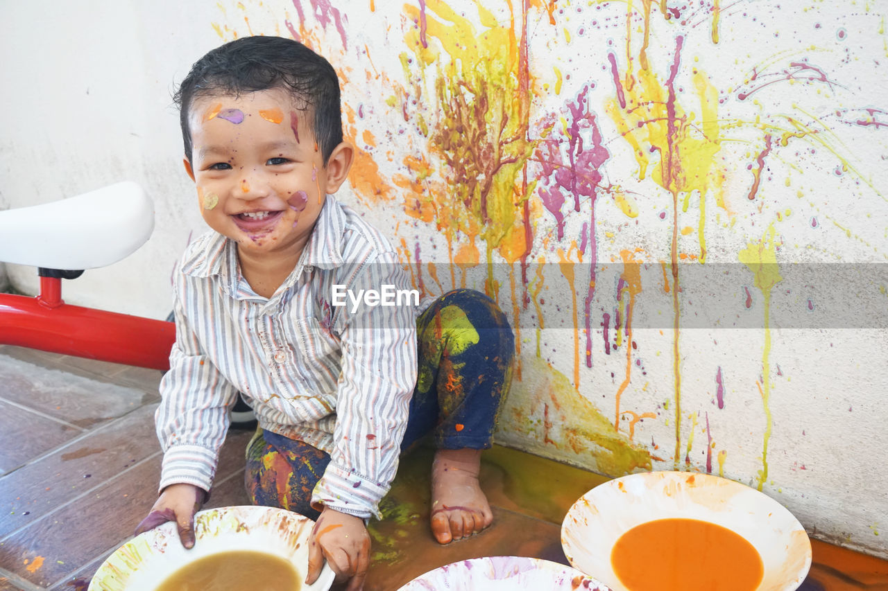 PORTRAIT OF SMILING BOY SITTING WITH CHOCOLATE