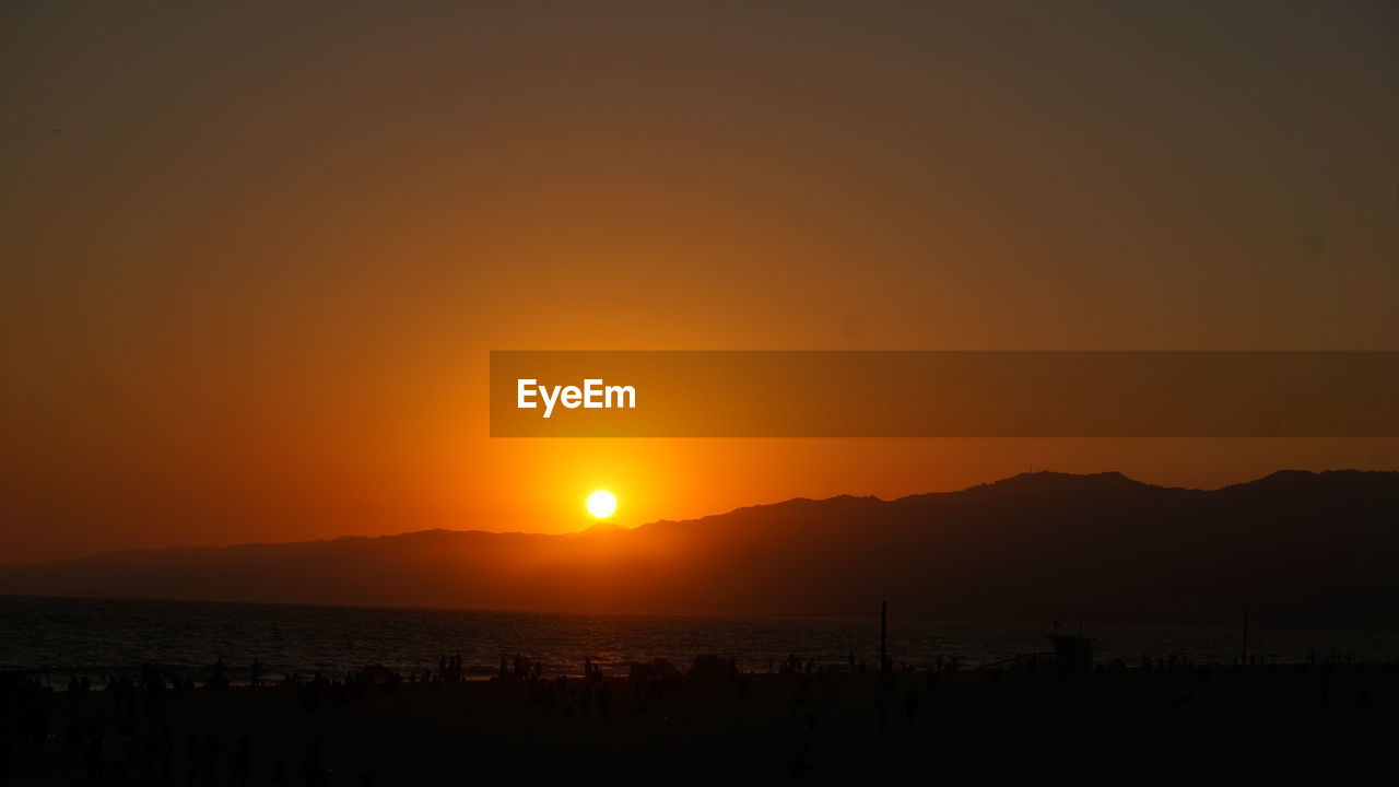 Scenic view of sea against orange sky