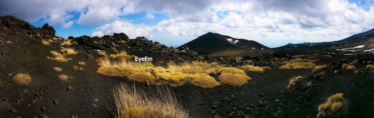 Scenic view of mountains against cloudy sky