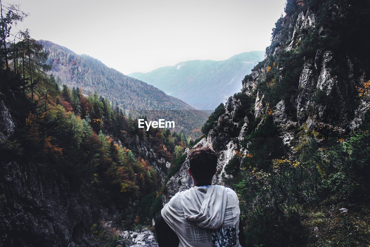 Rear view of man on mountain against sky