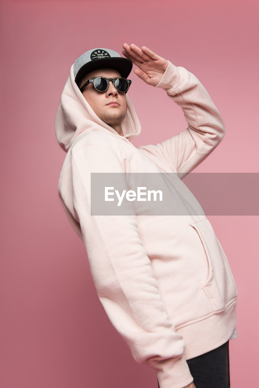 Man in sunglasses against pink background