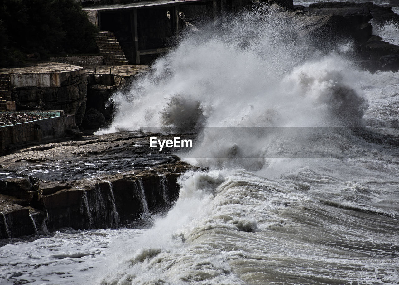 VIEW OF WAVES BREAKING ON ROCKS