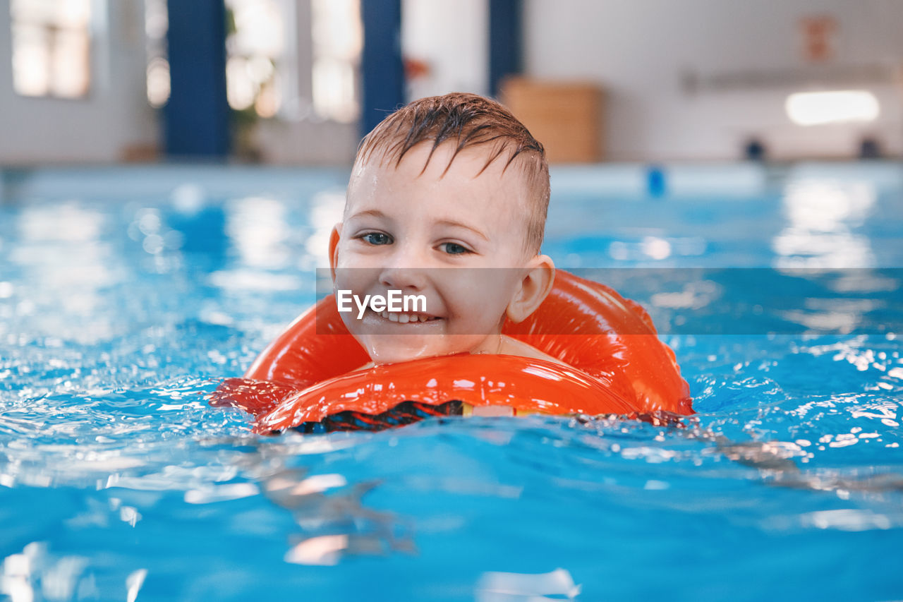 PORTRAIT OF A BOY SWIMMING IN POOL