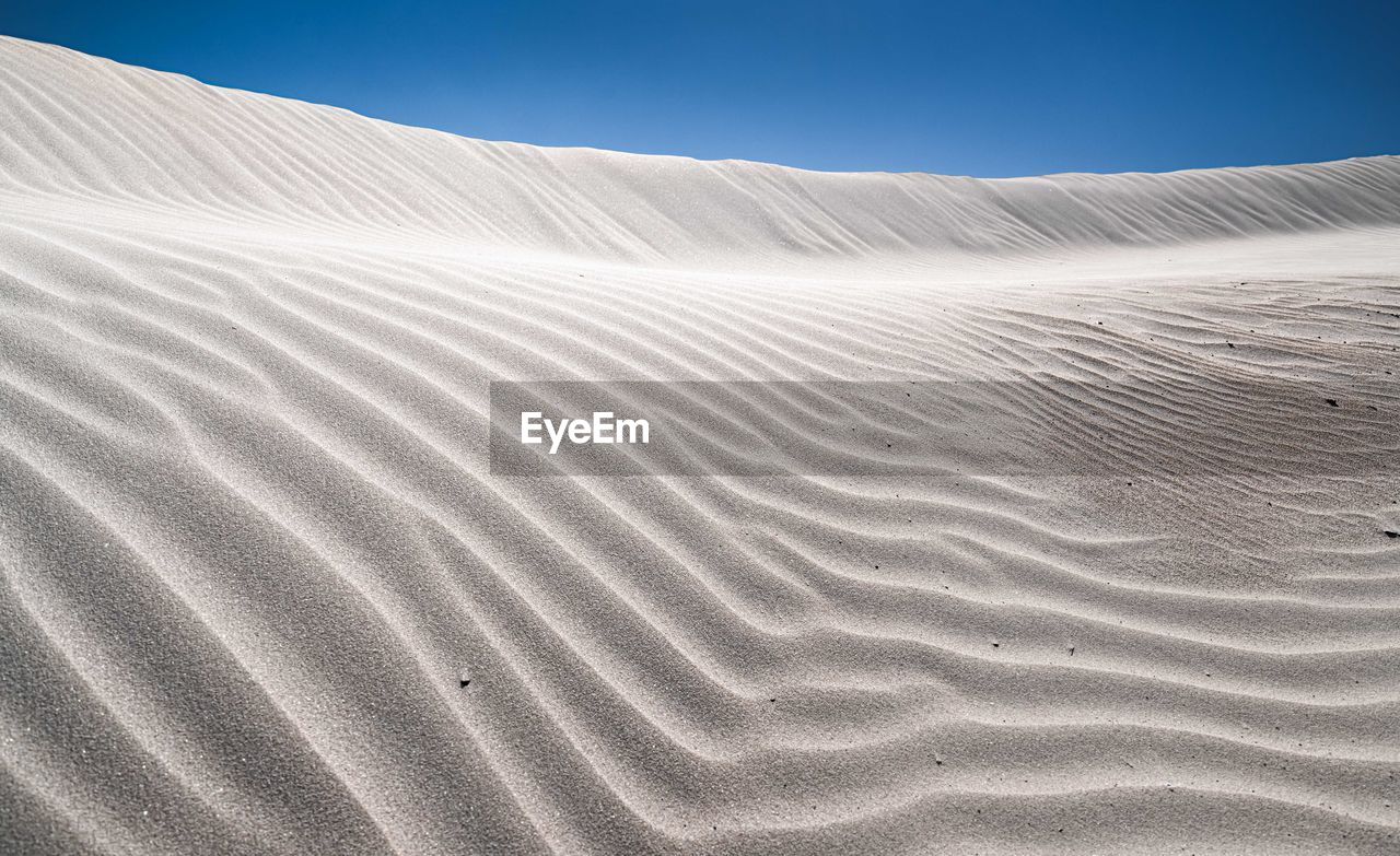 Sand dunes in desert against sky