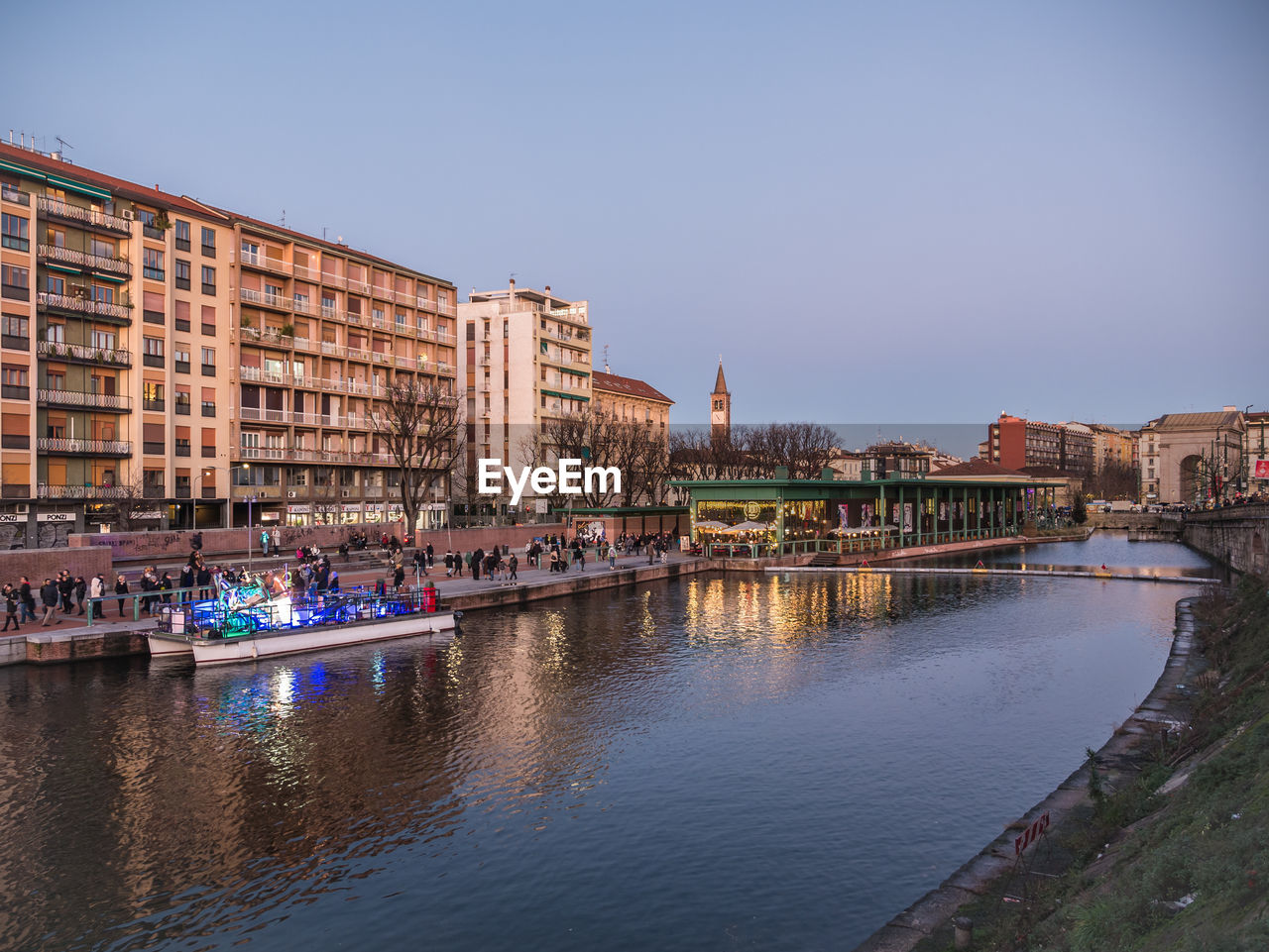 River by buildings against clear sky in city