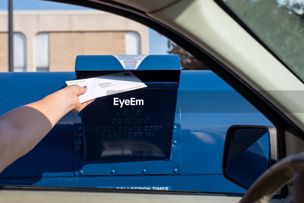 CROPPED IMAGE OF PERSON PHOTOGRAPHING CAR