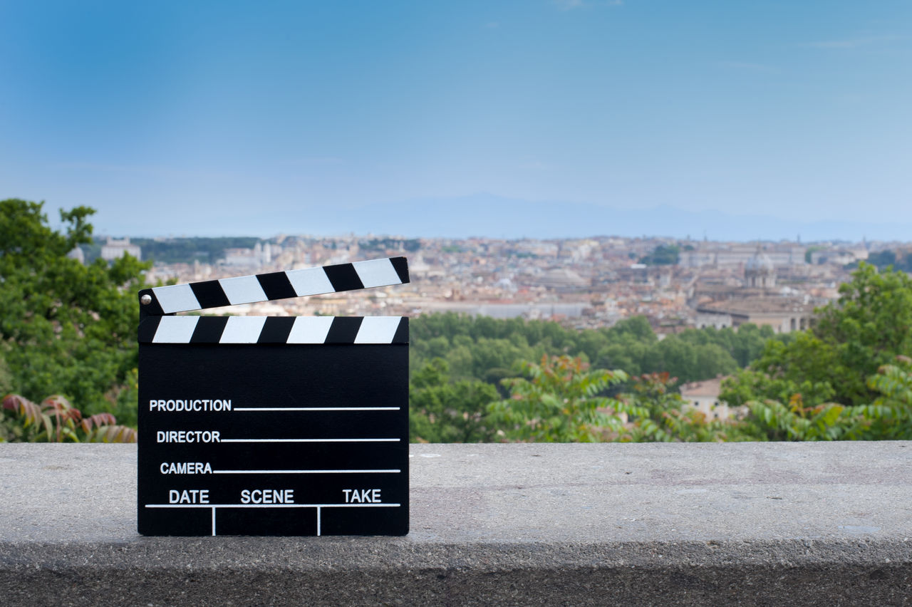 Film slate on wall against cityscape