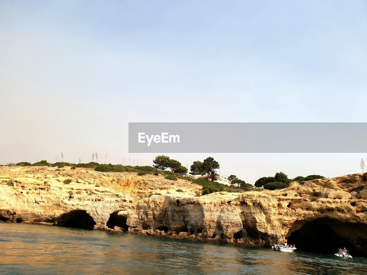 ROCK FORMATIONS ON SEA AGAINST CLEAR SKY