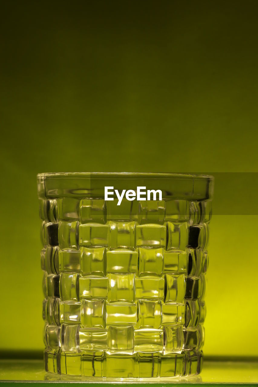 Close-up of empty glass against wall