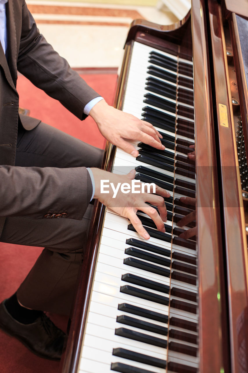 Midsection of man playing piano