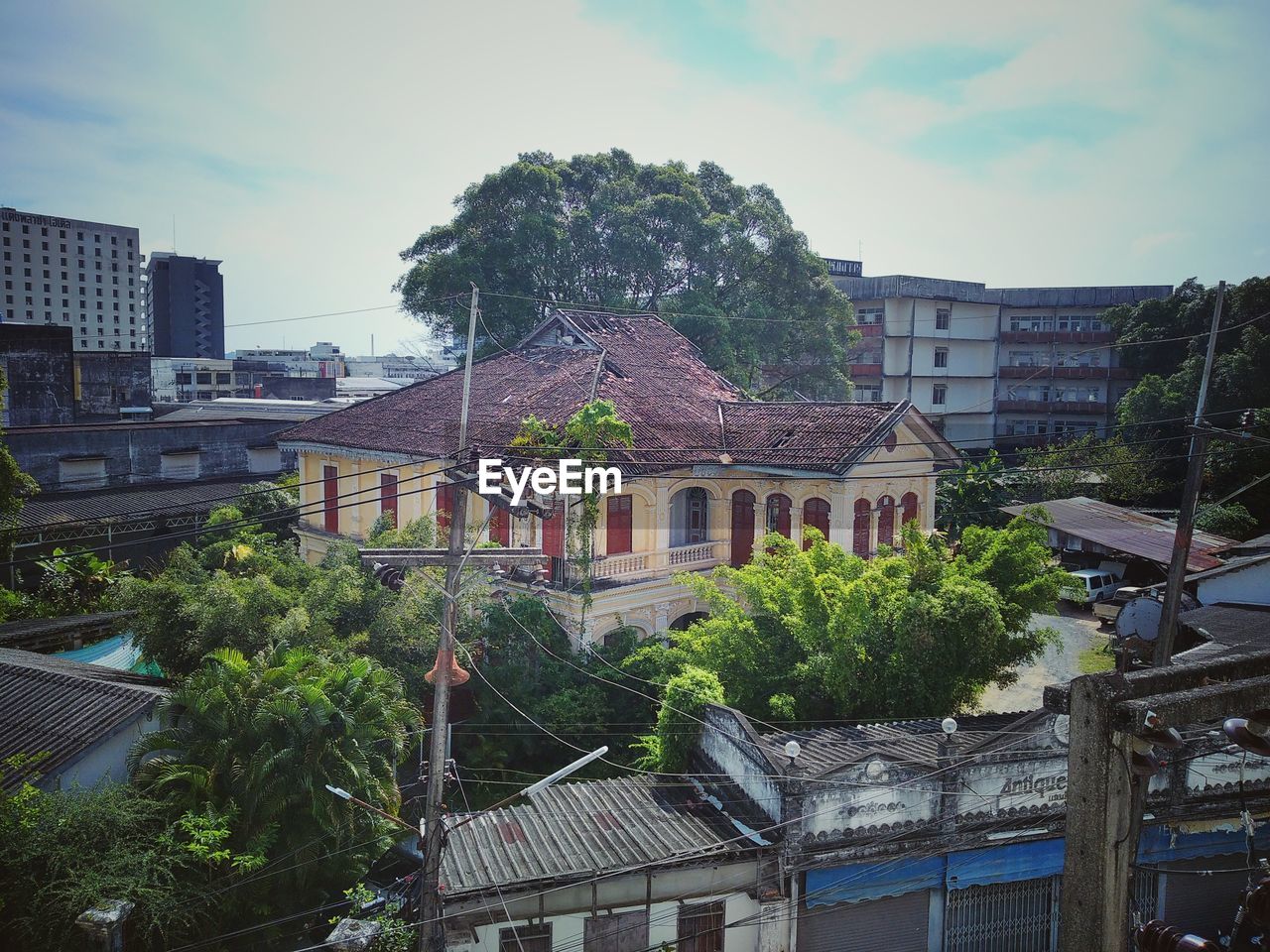 architecture, building exterior, built structure, building, city, urban area, cityscape, sky, residential district, tree, town, plant, nature, neighbourhood, house, cloud, residential area, no people, downtown, roof, outdoors, window, day, landmark, street