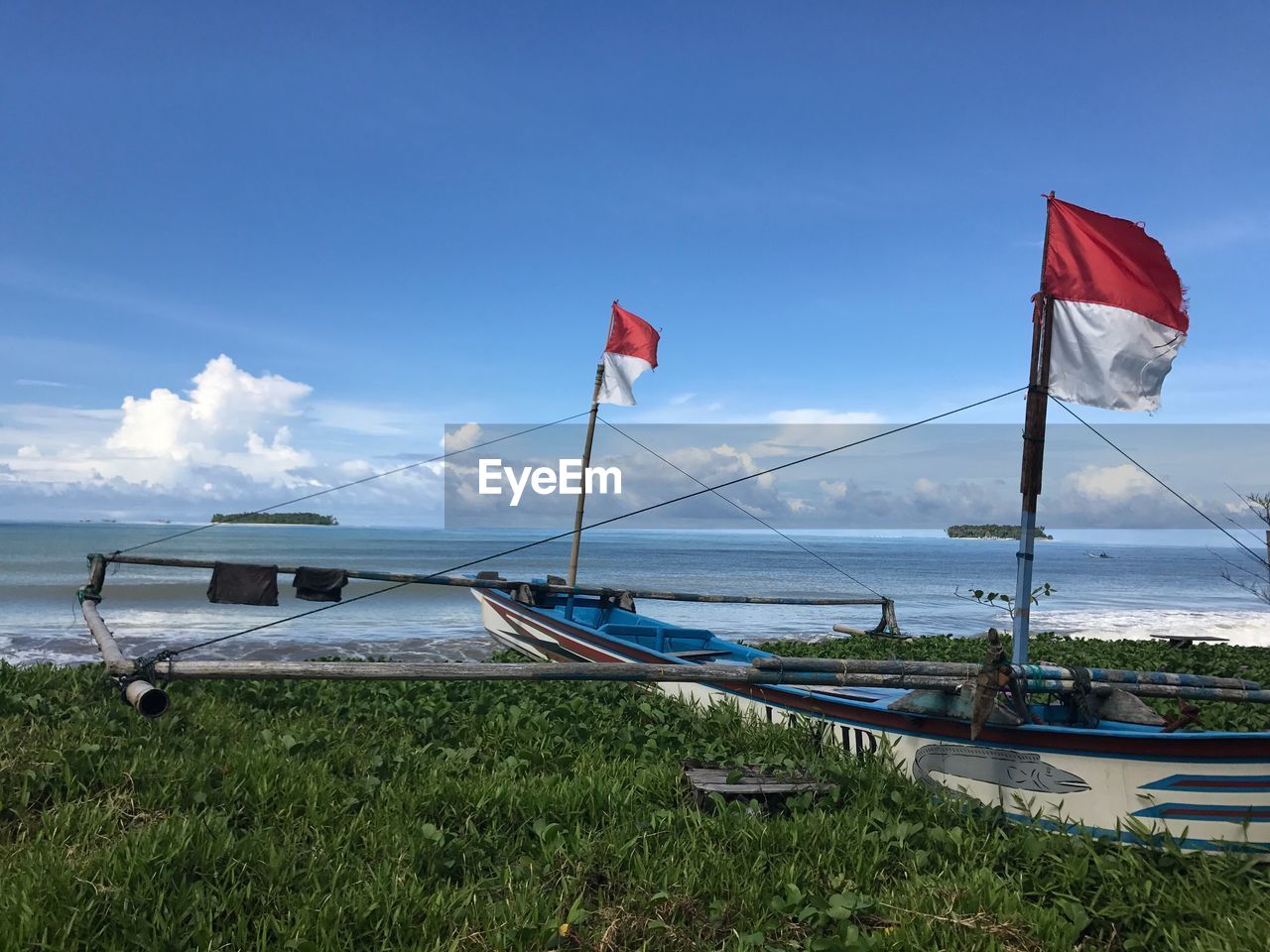 BOATS MOORED AT SEA AGAINST SKY