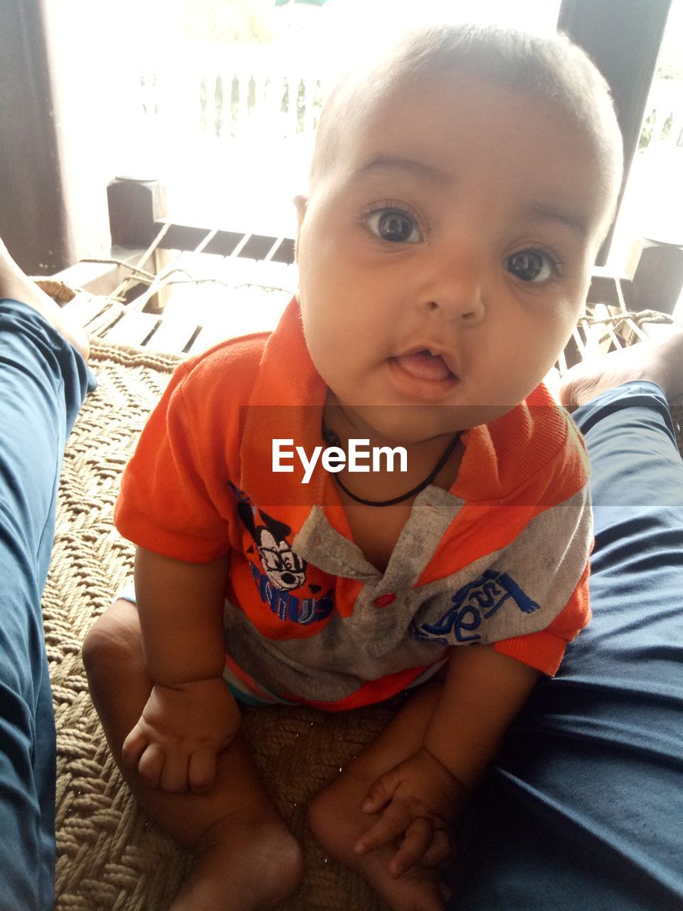 PORTRAIT OF CUTE BABY SITTING ON BED AT HOME