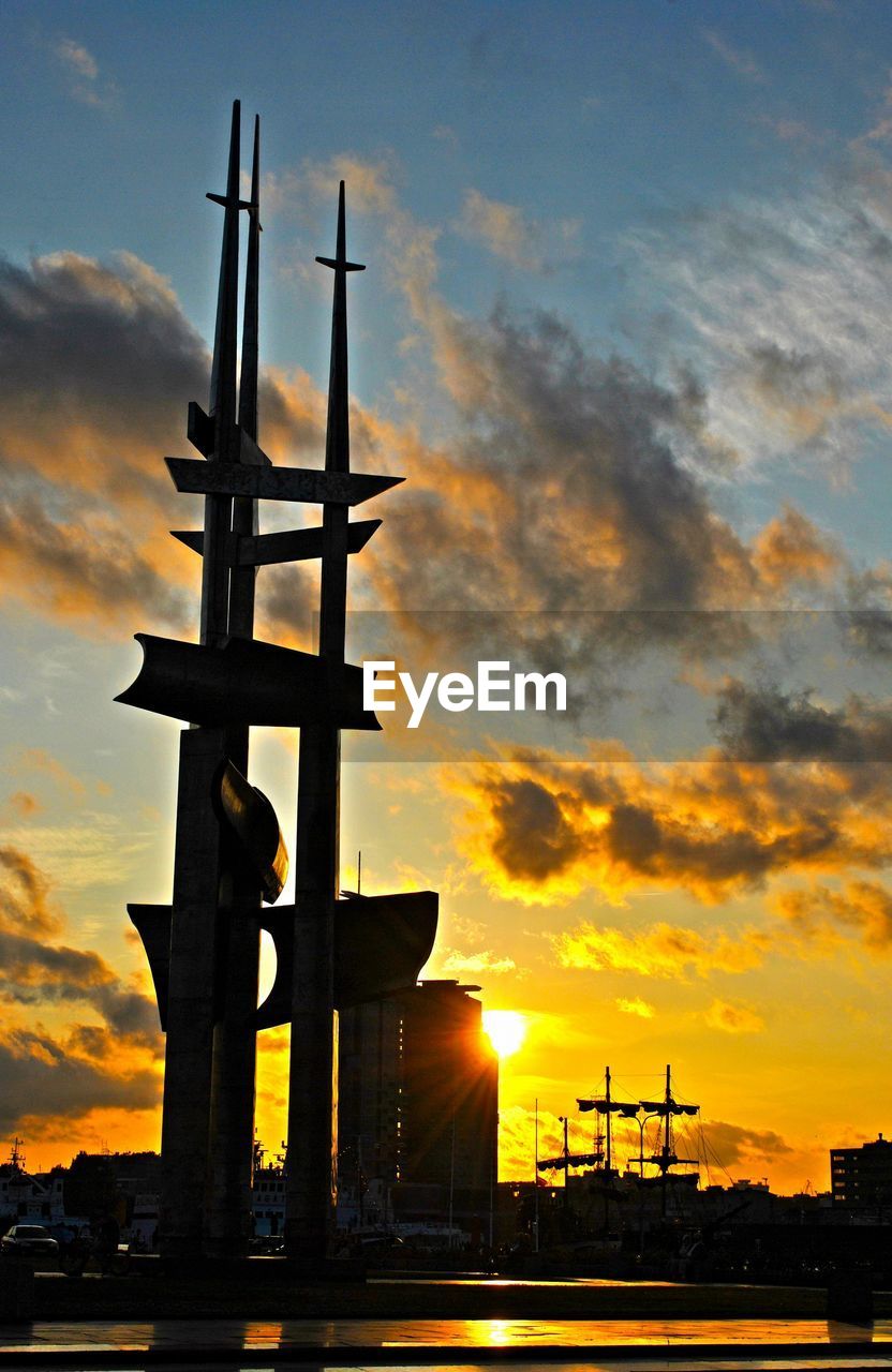 Low angle view of towers against sky during sunset