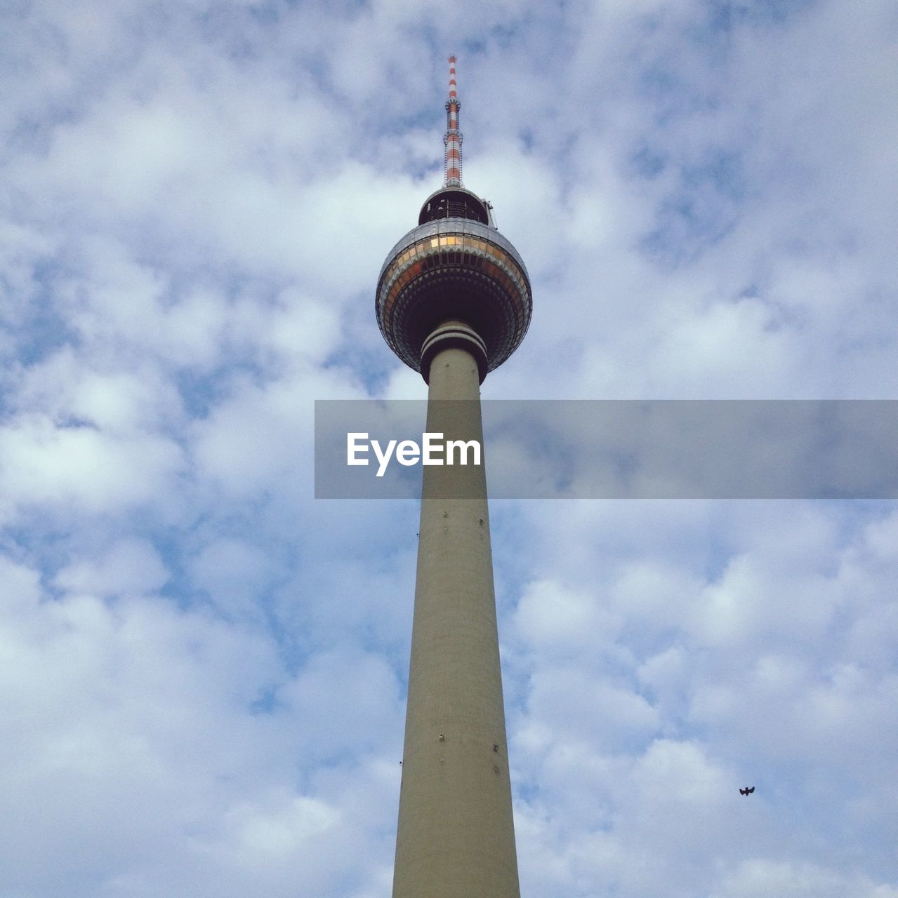 Low angle view of fernsehturm against cloudy sky